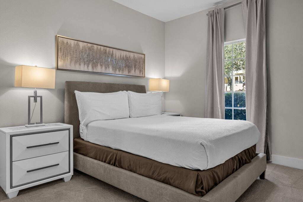 Estate Suite bedroom with upholstered headboard and bedside lamps